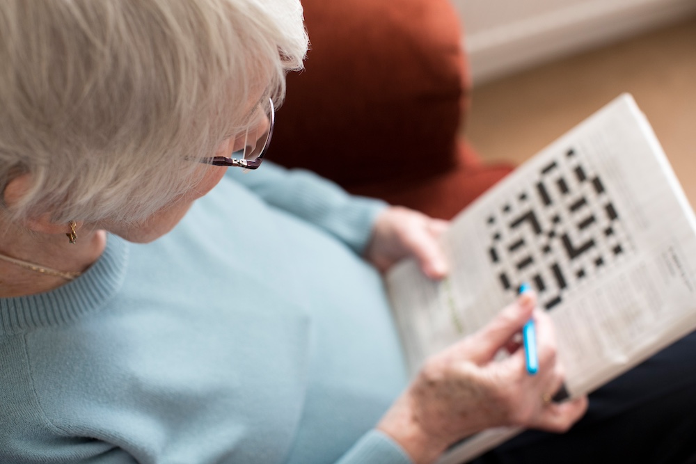 A senior woman working on a crossword puzzle