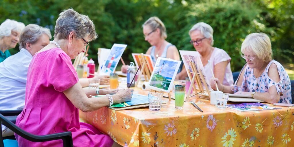 A group of seniors taking a painting class at the memory care in Thousand Oaks