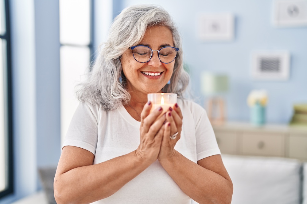 A senior resident of the dementia care in Thousand Oaks using an essential oil candle 