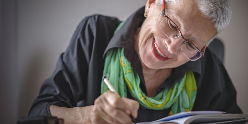 A happy senior woman writing in her journal at the senior living in Thousand Oaks