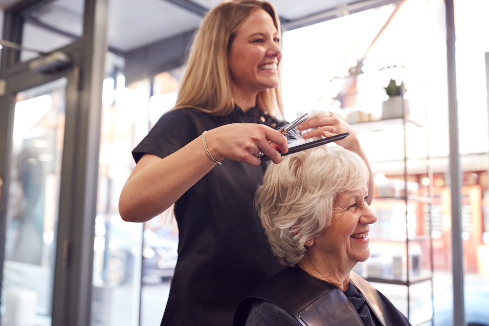 A happy senior woman getting her hair done at the salon